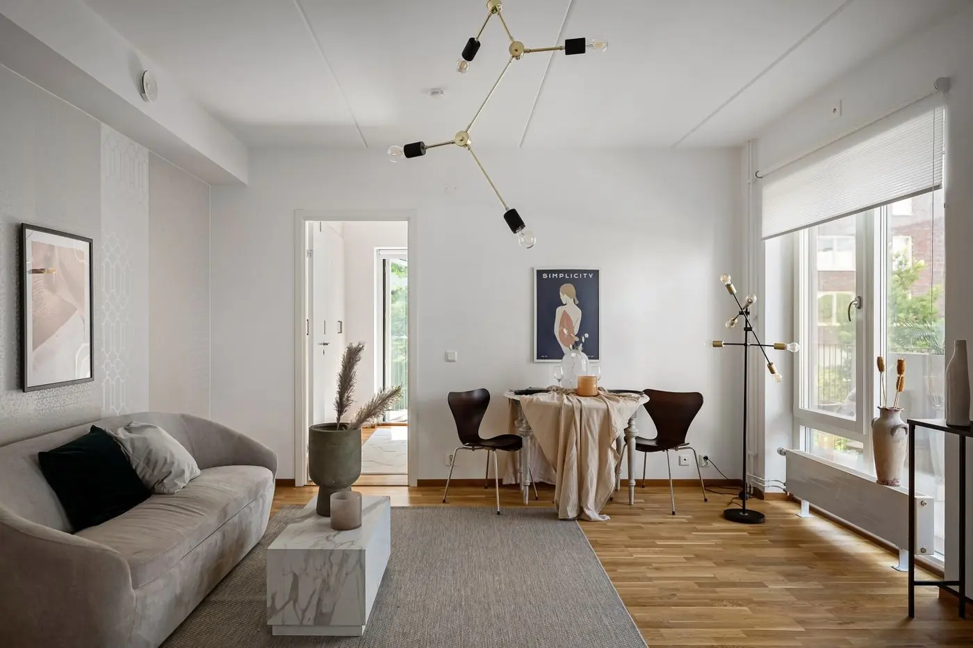 Lichte woonkamer met eethoek, grote ramen en gladde witte wanden